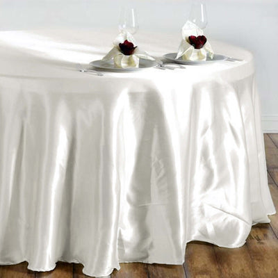 Elegant satin tablecloth draping over a round table set for two.