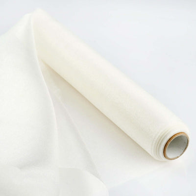 Roll of sheer white fabric on a plain backdrop for crafting and design.