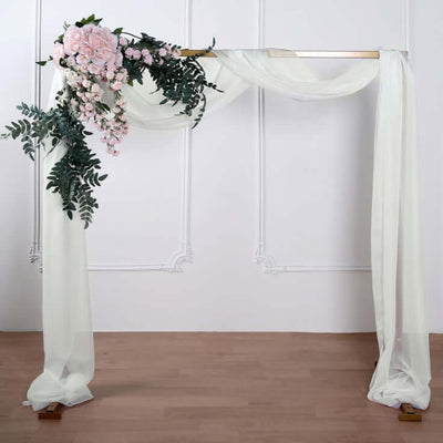 Floral wedding arch with draped fabric and greenery decorations.