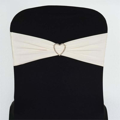 Ivory chair sash with heart-shaped embellishment on black chair.