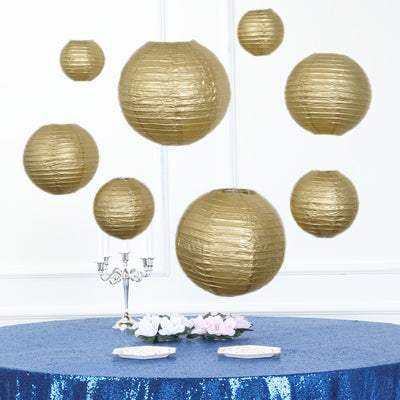 Gold paper lanterns floating above a blue sequined table with flowers.