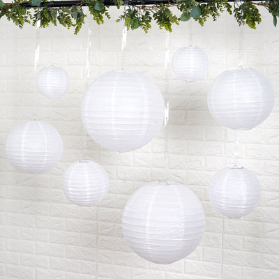 White paper lanterns hanging decoratively against a textured wall background.
