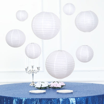 White paper lanterns hanging above a sparkling blue table setting.