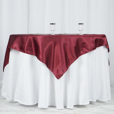 Elegant burgundy satin tablecloth draped over a white table