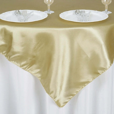 Gold satin tablecloth draped elegantly over a table with plates and cutlery.