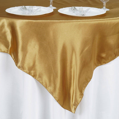 Gold satin tablecloth draped elegantly over a white table.