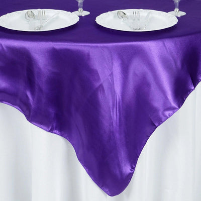 Purple satin tablecloth draped elegantly over a white table.