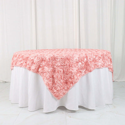 Pink rose-patterned tablecloth draped over a white table.