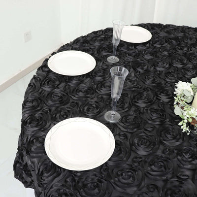 Elegant black rose tablecloth with plates and glasses arranged for a dining setting.