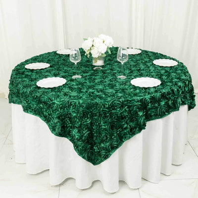 Green rose-patterned tablecloth on a round table with white plates and glasses.
