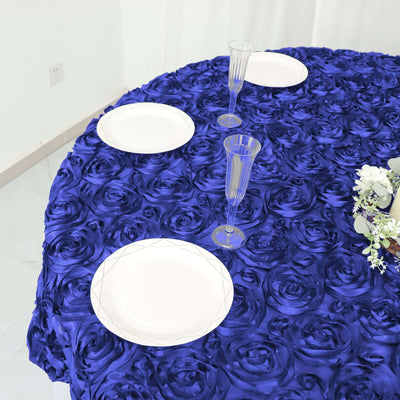 Blue rose-patterned tablecloth with plates and glasses set for dining.