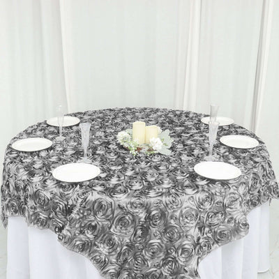 Round black and white rose-patterned tablecloth on a dining table.