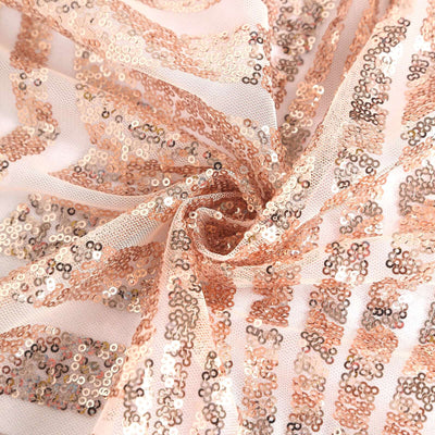 Rose gold sequin fabric with intricate patterns and texture.