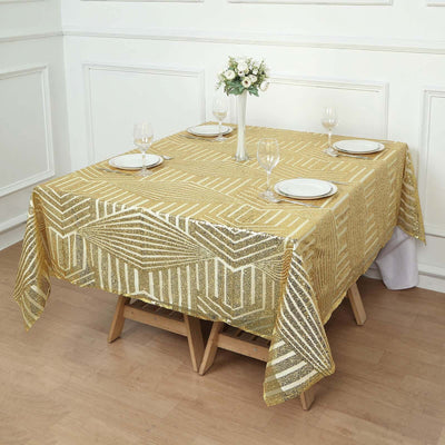 Gold geometric tablecloth on a dining table set with plates and glasses.