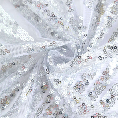 Silver sequin fabric with a mesh backing, showcasing sparkling details.