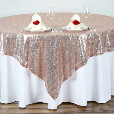 Rose gold sequined tablecloth on a dining table set for two.