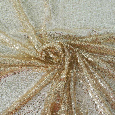 Gold sequined fabric draped elegantly on a textured surface.