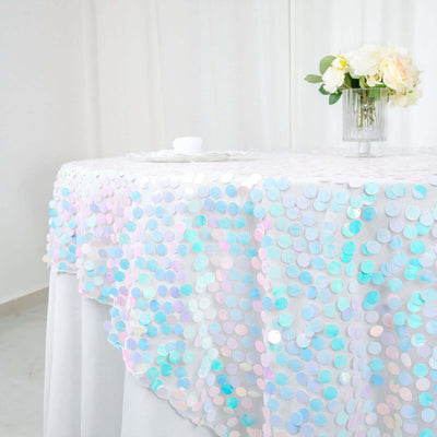 Iridescent sequin tablecloth draped elegantly over a table with flowers.