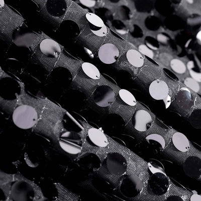 Black sequined fabric with shiny circular embellishments.
