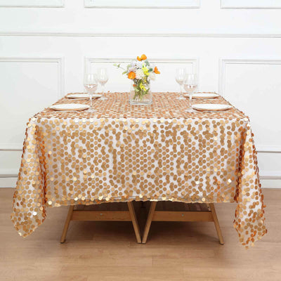 Gold sequin tablecloth on a dining table with floral centerpiece and glassware.