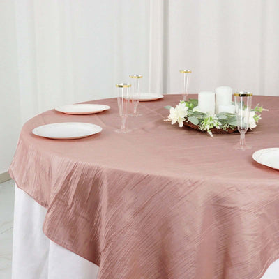 Elegant rose tablecloth draped over a round table set for a dinner party.