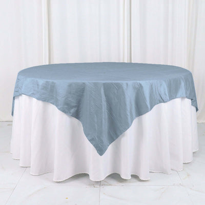 Round blue tablecloth draped elegantly over a white table.