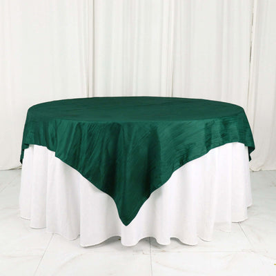Green round tablecloth draped elegantly over a white table.