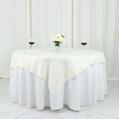 Elegant round table set with wine glasses and white floral centerpiece.