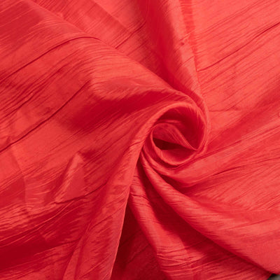 Crinkled red fabric texture in a swirling pattern.