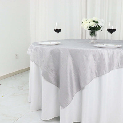Elegant silver tablecloth draped over a dining table with wine glasses.