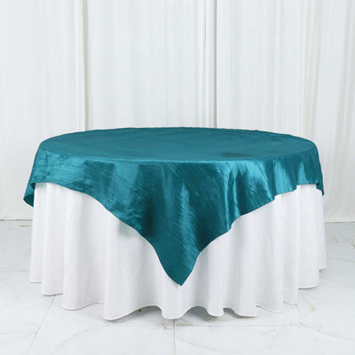 Teal satin tablecloth draped on a round table.