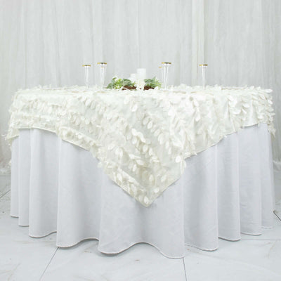 White table with elegant leaf-patterned tablecloth and decorative candles.