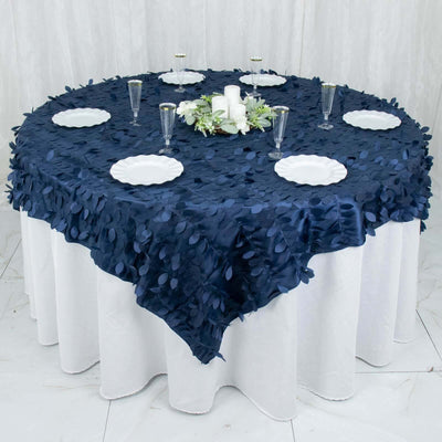 Navy blue tablecloth with leaf design on round table set for dining.