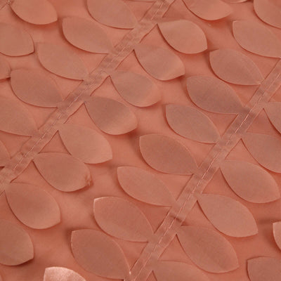 Peach fabric with leaf-shaped appliqués, showcasing texture and design details.