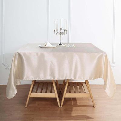 Elegant beige tablecloth draped over a wooden table with decorative candles.