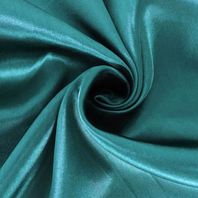 Teal silk fabric close-up showing smooth texture and sheen.
