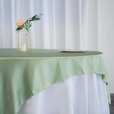Elegant green tablecloth with floral centerpiece and gold accents.