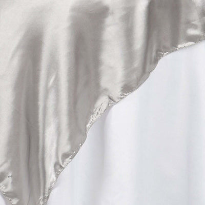 Silver satin fabric draped elegantly on a white background.
