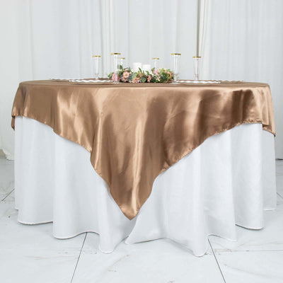 Elegant brown satin tablecloth draped over a white table with floral centerpiece.