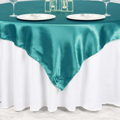 Teal satin tablecloth draped elegantly over a white table.
