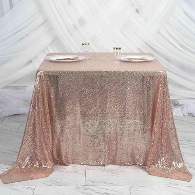 Rose gold sequin tablecloth draped over a table with elegant dining setup.