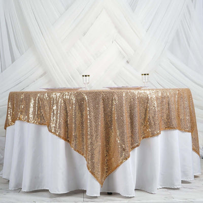 Gold sequin tablecloth draping over a white table against a soft backdrop.