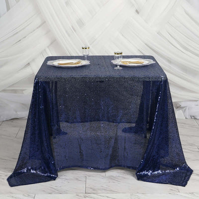 Navy sequin tablecloth draped over a table with plates and glasses
