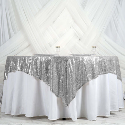 Silver sequin tablecloth draping elegantly over a white table.