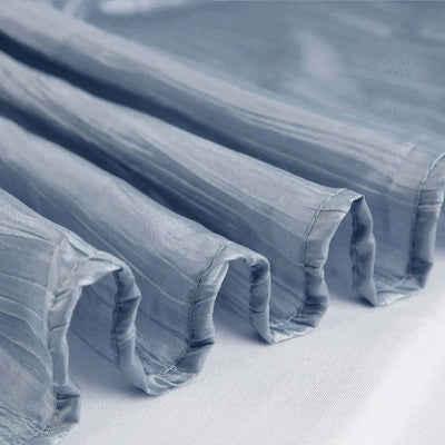 Blue sheer fabric draped elegantly with soft pleats and texture.