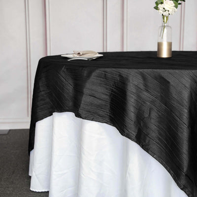 Black tablecloth draped over a white table, elegantly styled for an event.