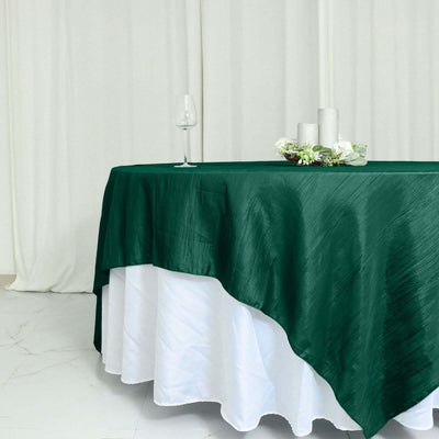 Green tablecloth draped elegantly over a white table with decorative candles.