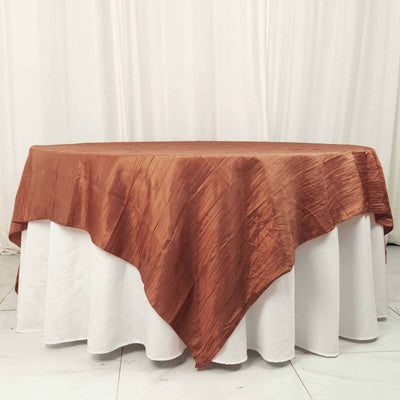 Copper tablecloth draped over a round table in a studio setting.