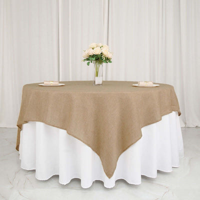 Brown burlap tablecloth draped over a white table with floral centerpiece.