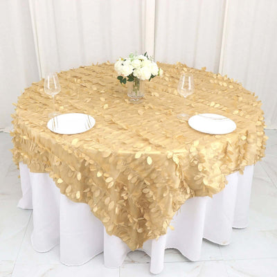 Gold leaf tablecloth draped over a round table with white plates and glasses.